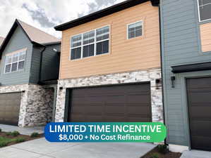 View of front of house with stone siding and an attached garage