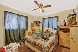 Carpeted bedroom featuring a ceiling fan