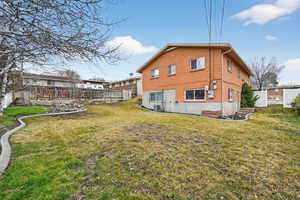 Rear view of house with a fenced backyard and brick siding