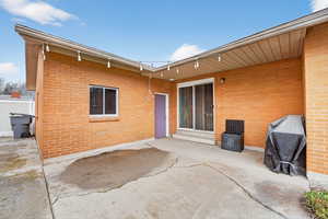 Rear view of property with a patio and brick siding