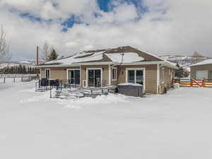 Rear of the home is flanked with a gorgeous trex deck, three large vinyl sliders, and a hot tub.