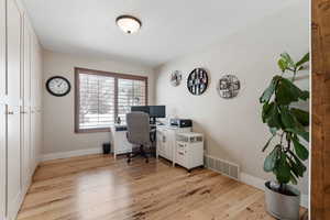 Spacious office with views out to the front of the home. Lovely hardwood flooring. Built-in cabinetry is included. Barn style doors.