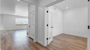 Corridor featuring light wood finished floors and recessed lighting