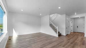Unfurnished living room featuring recessed lighting, wood finished floors, and a textured ceiling