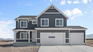 View of front of property featuring roof with shingles, a mountain view, and concrete driveway