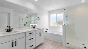 Full bathroom featuring double vanity, a shower stall, a bath, and recessed lighting