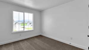 Spare room featuring carpet and baseboards