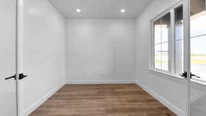 Unfurnished room featuring light wood-type flooring, recessed lighting, and french doors