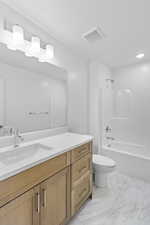 Full bath featuring vanity,  shower combination, light marble finish flooring, and recessed lighting
