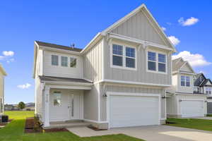 Craftsman-style house featuring a garage, board and batten siding, a shingled roof, driveway, and a front yard