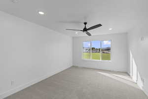 Carpeted spare room featuring a ceiling fan and recessed lighting