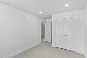 Unfurnished bedroom featuring carpet flooring, a closet, and recessed lighting