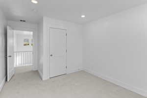 Unfurnished bedroom featuring light carpet and recessed lighting