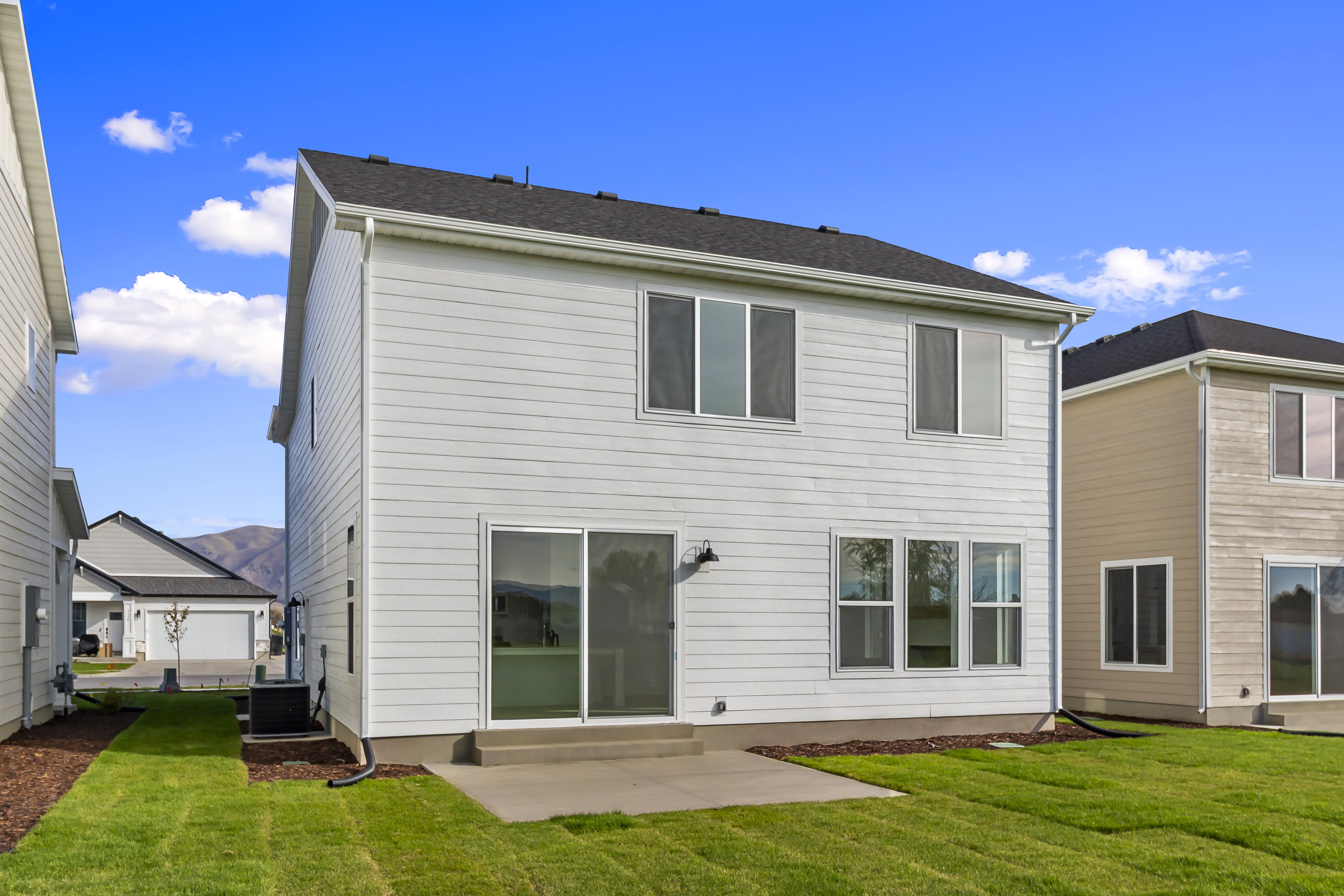 Rear view of property with a lawn and a patio area
