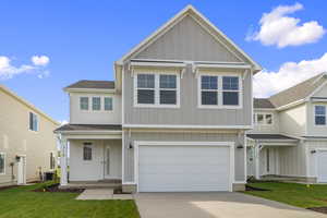 View of front of house featuring board and batten siding, a garage, concrete driveway, and roof with shingles
