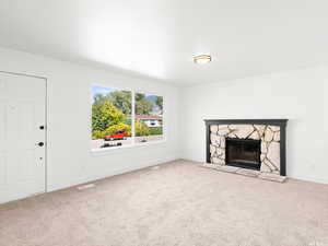 Unfurnished living room featuring carpet and a fireplace