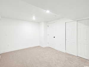Finished basement with baseboards and light colored carpet