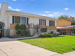 View of front facade with a front lawn, brick siding, and a shingled roof