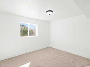 Spare room featuring carpet floors and baseboards