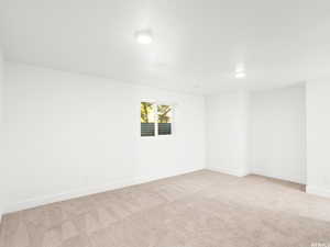 Unfurnished room with light carpet and a textured ceiling