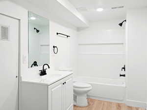 Full bathroom with vanity, tub / shower combination, and light wood-style floors