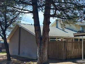 North Rear View of home's exterior featuring a fenced back patio & brick siding.
