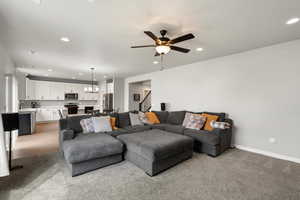Living room featuring recessed lighting, ceiling fan, and light carpet