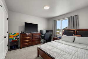 Bedroom with light carpet and a closet