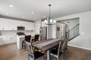 Dining room with light wood-type flooring and a chandelier