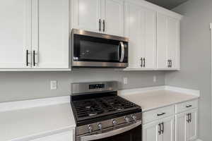 Kitchen with stainless steel appliances and white cabinets