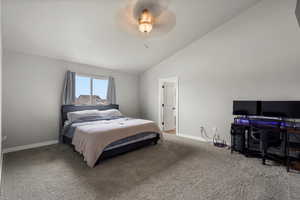 Bedroom with carpet flooring, a ceiling fan, lofted ceiling, and a desk