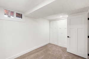 Finished basement with carpet flooring and a textured ceiling