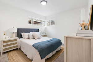 Bedroom featuring light carpet and baseboards