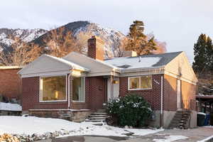View of front facade with a chimney, a mountain view, and brick siding