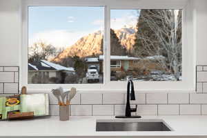 Kitchen view of a sink and light stone counters