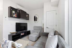 Living room with a wall mounted mini split and light colored carpet