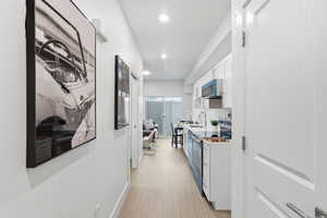 Hall featuring light wood-type flooring and recessed lighting