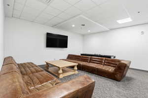 Living room with a paneled ceiling and carpet