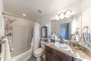 Full bath featuring vanity, shower / tub combo with curtain, and a textured ceiling