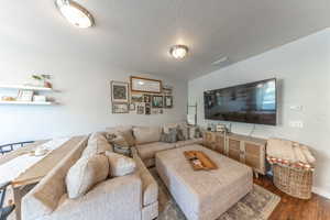 Living room with wood finished floors and a textured ceiling