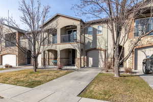 Mediterranean / spanish home featuring stucco siding, stone siding, driveway, and a balcony