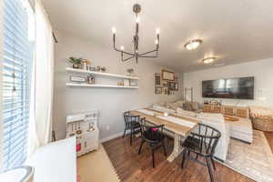 Dining space featuring plenty of natural light, wood finished floors, and a chandelier