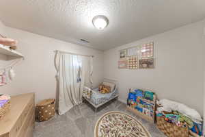 Carpeted bedroom featuring a textured ceiling