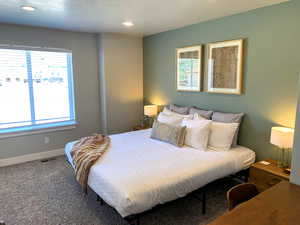 Carpeted bedroom featuring multiple windows and recessed lighting