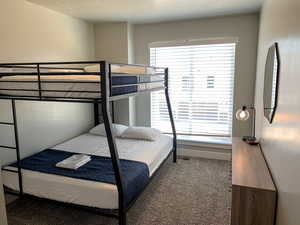 Bedroom featuring dark carpet and a textured ceiling