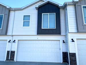 View of home's exterior with board and batten siding, a garage, and driveway