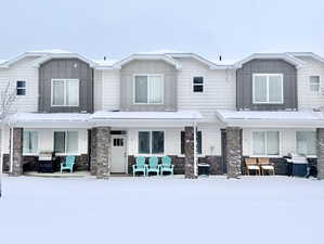 View of front of house featuring stone siding, board and batten siding, and covered porch