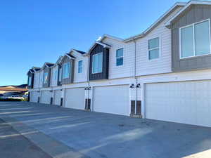 View of side of home with board and batten siding, a garage, a residential view, and driveway