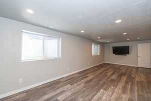 Basement with dark wood-type flooring and recessed lighting