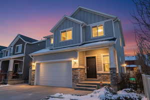 Craftsman inspired home featuring board and batten siding, stone siding, an attached garage, concrete driveway, and a porch